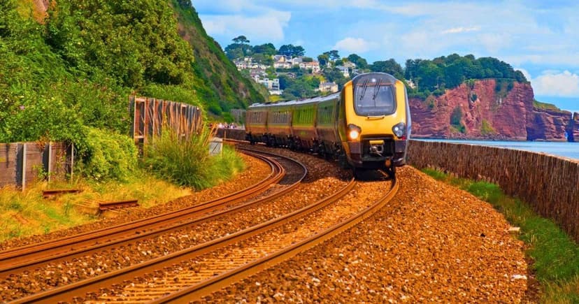 Seaside Train Ride: Waves Crash Over Tracks!